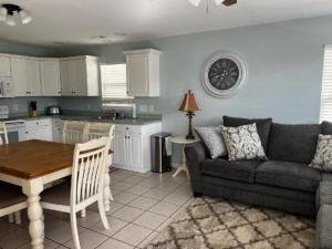 uma sala de estar com um sofá, uma mesa e uma cozinha em Cooper's Lighthouse Home em Myrtle Beach