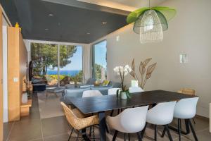 a dining room with a black table and white chairs at Villa Verde Costa Brava - BY EMERALD STAY in Begur