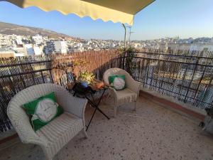 d'une terrasse avec 2 chaises et une table sur un balcon. dans l'établissement Eagle's Nest, à Athènes