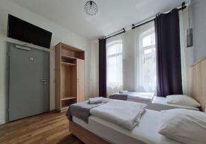 ein Schlafzimmer mit zwei Betten und einem Flachbildfernseher in der Unterkunft Aparthotel Lenau in Hannover