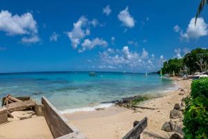 a beach with the ocean and a blue sky at Waterside 303 by Barbados Sothebys International Realty in Saint James