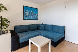 a living room with a blue couch and a table at Am Lichtenberg in Daisendorf