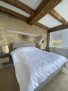 Villa Ster et Mer في Plobannalec-Lesconil: غرفة نوم بسرير ابيض ونافذة