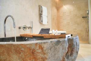 a bathroom with a bath tub with a laptop on it at Les Regalia Hôtel & Spa in Sainte-Lucie de Porto-Vecchio