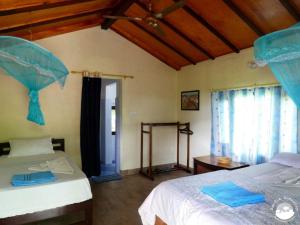 een slaapkamer met 2 bedden en een parasol bij Bardia Homestay Pvt. Ltd. in Bhurkīā