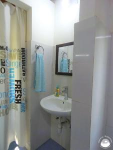Baño blanco con lavabo y espejo en Bardia Homestay Pvt. Ltd., en Bhurkīā