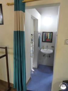 a bathroom with a sink and a shower curtain at Bardia Homestay Pvt. Ltd. in Bhurkīā