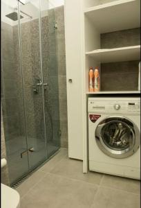 a bathroom with a washing machine and a glass shower at SYNTAGMA VOULIS STREET MODERN APARTMENT in Athens