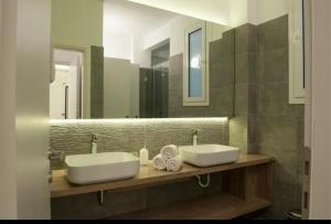 a bathroom with two sinks and a large mirror at SYNTAGMA VOULIS STREET MODERN APARTMENT in Athens