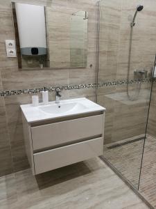 a bathroom with a white sink and a shower at Tower Apartman Kőszeg in Kőszeg