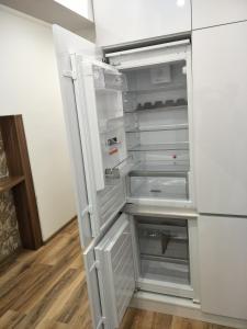 un frigorifero vuoto con la porta aperta in una stanza di Tower Apartman Kőszeg a Kőszeg