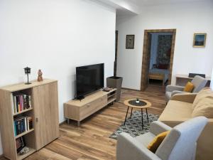 a living room with a couch and a tv at Tower Apartman Kőszeg in Kőszeg