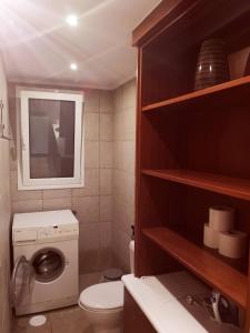 een kleine badkamer met een toilet en een wasmachine bij SKAMAShouse in Athene