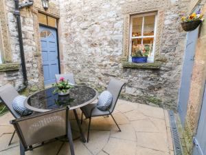 a patio with a table and chairs in front of a building at Knoll Cottage in Bakewell