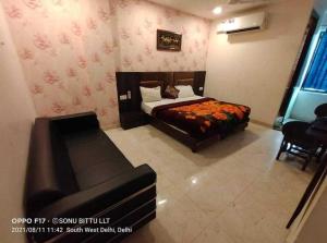 - une chambre avec un lit et un canapé dans l'établissement OYO Hotel Shivam In, à New Delhi