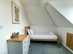 a bedroom with a bed and a dresser in a attic at Torquay holiday home near the sea in Torquay