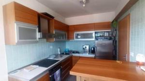 a kitchen with wooden cabinets and a stainless steel refrigerator at Villa West Point in Okrug Donji