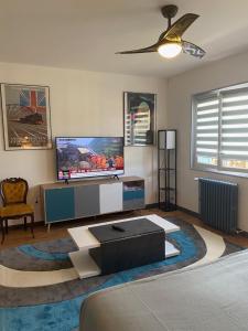 - un salon avec une télévision et un canapé dans l'établissement Avenue de la Gare, à Riscle