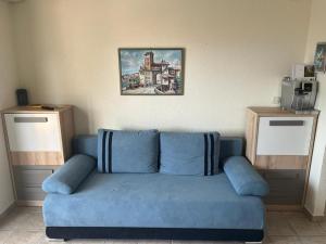 a blue couch in a living room with a picture on the wall at Villa West Point in Okrug Donji