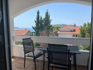 a patio with two chairs and a table on a balcony at Villa West Point in Okrug Donji