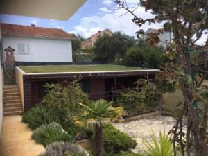 a garden with a building with a green roof at Villa West Point in Okrug Donji +6 photos