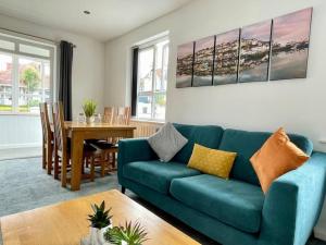 uma sala de estar com um sofá azul e uma mesa em Torquay holiday home near the sea em Torquay