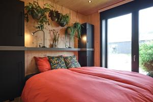 1 dormitorio con 1 cama y plantas en la pared en GreenFloat Boskoop #2 Mica & Luca en Boskoop