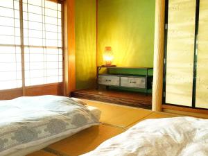 ein Schlafzimmer mit einem Bett und einem Tisch mit einer Lampe in der Unterkunft 余呉の里山-ランプの宿-さくら in Nagahama