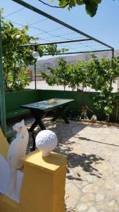 a white cat sitting on a wall next to a table at Apartments Vesna in Pag