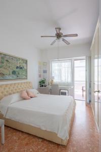sypialnia z łóżkiem i wentylatorem sufitowym w obiekcie Abitazione per 4 con Terrazzo - Mare+Metro vicine w mieście Lido di Ostia