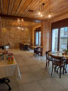a restaurant with tables and chairs and a brick wall at Taverna de la Sal Boutique Hotel in L'Escala