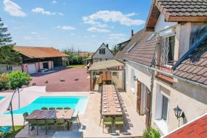 un patio esterno con tavoli e sedie accanto alla piscina di Crazy Villa Le Tertre 28 - Heated pool - Basket - 2h Paris - 44p a Courtalain