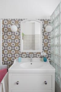 ein Badezimmer mit einem weißen Waschbecken und einem Spiegel in der Unterkunft Stella Polare Luxury Loft in Lido di Ostia