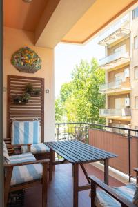 patio ze stołem i ławkami na balkonie w obiekcie Abitazione per 4 con Terrazzo - Mare+Metro vicine w mieście Lido di Ostia
