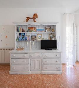 biała komoda z telewizorem na górze w obiekcie Abitazione per 4 con Terrazzo - Mare+Metro vicine w mieście Lido di Ostia