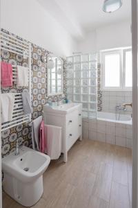 ein Badezimmer mit Waschbecken, Toilette und Badewanne in der Unterkunft Stella Polare Luxury Loft in Lido di Ostia + 30 Fotos