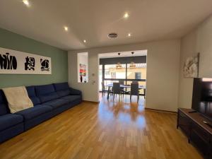 sala de estar con sofá azul y comedor en CASA NEUS, casa junto a Barcelona, en Sant Feliu de Llobregat