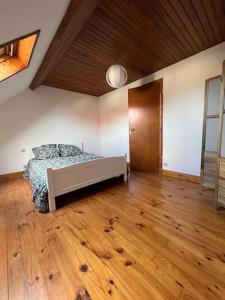 1 dormitorio con 1 cama y suelo de madera en Entre terre et mer, en Rinxent