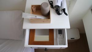 a white counter with a microwave in a room at 棲息所 Habitat Inn in Yuanlin