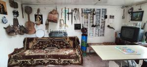 a room with a couch and a table and a wall with guitars at Nor Takh in Khndzoresk