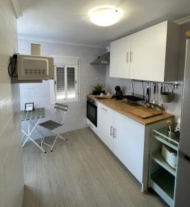 une cuisine avec des placards blancs et un comptoir dans l'établissement Apartamento Henko, à Huelva