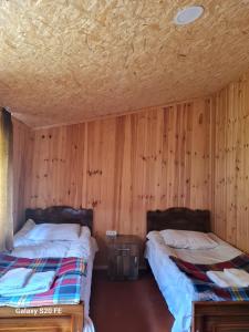 2 Betten in einem Zimmer mit Holzwänden in der Unterkunft LIO in Glola