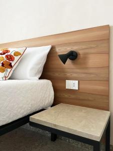 a bed with a wooden headboard with a bench next to it at La casa di Irene - Suites con vista in Ragusa