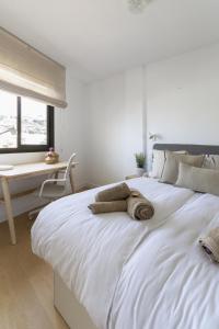 een slaapkamer met een groot wit bed en een bureau bij Apartamento Sunny Holidays in Puerto Rico de Gran Canaria