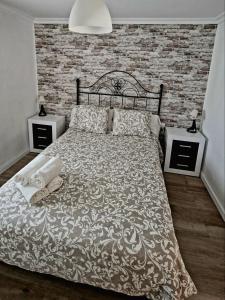 - une chambre avec un lit et un mur en briques dans l'établissement Apartamento Henko, à Huelva