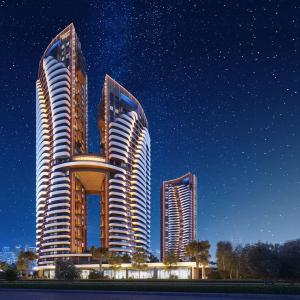 three tall buildings in a city at night at Luxury residence with sea view in Konak