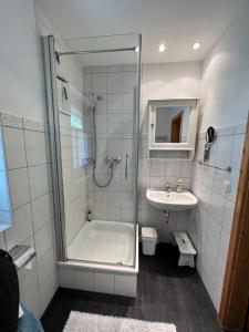 a bathroom with a shower and a tub and a sink at Ferienwohnung Gänseweg in Graal-Müritz