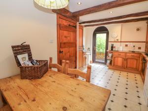 cocina con mesa de madera en una habitación en The Haybarn, en Lichfield