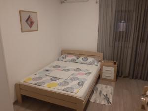 um pequeno quarto com uma cama com uma estrutura em madeira em Apartman Sema em Donji Štoj