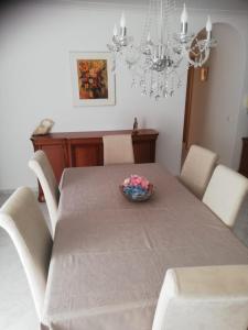 a dining room table with a bowl of flowers on it at Apartamento Saint Martin in Armação de Pêra